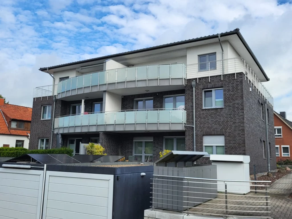 Ein Mehrfamilienhaus mit Balkonen und Edelstahlgeländer
