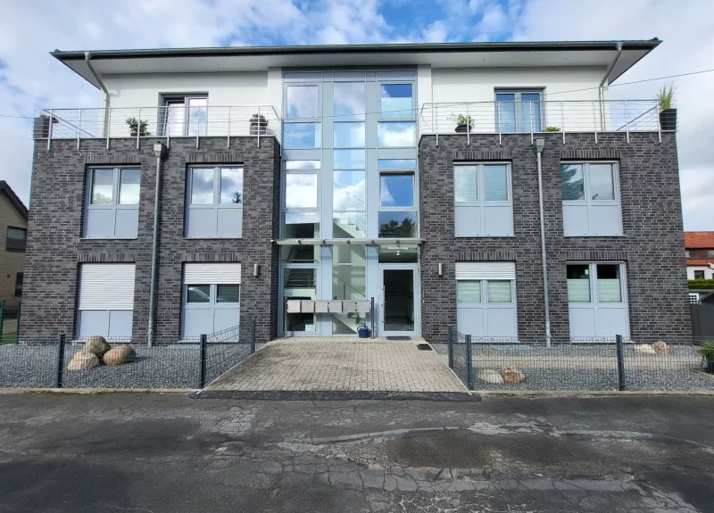 Ein Mehrfamilienhaus mit Balkonen und Edelstahlgeländer