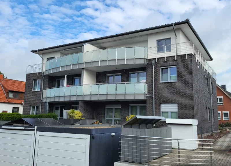 Ein Mehrfamilienhaus mit Balkonen und Edelstahlgeländer