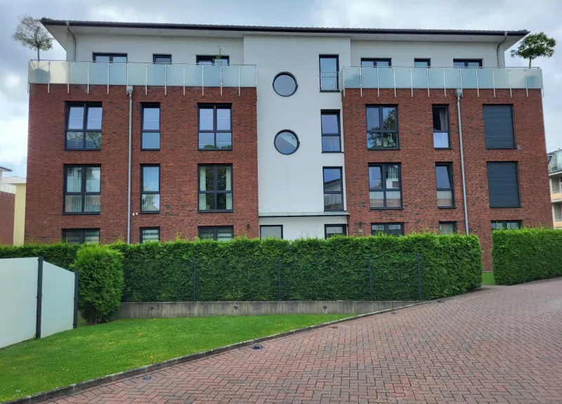 Mehrfamilienhaus mit Klinkerfassade und Balkon mit Edelstahlgeländer