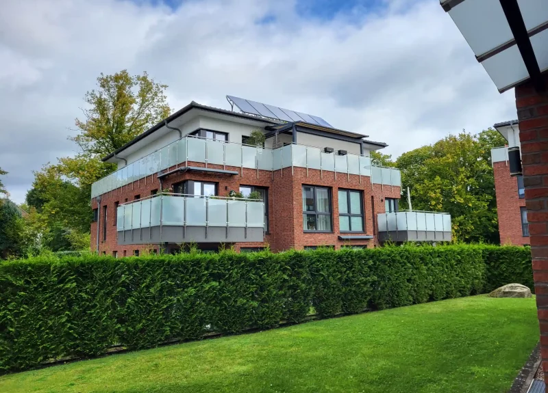 Mehrfamilienhaus mit Klinkerfassade und Balkon mit Edelstahlgeländer
