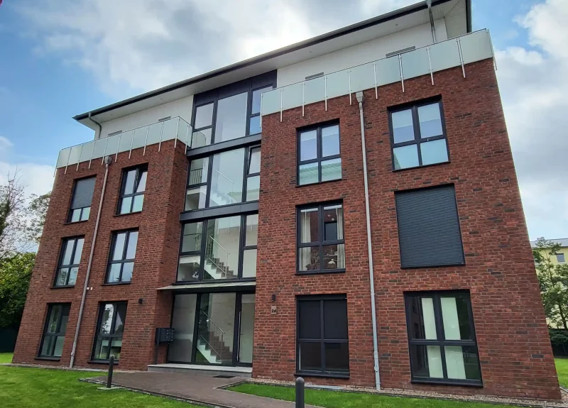 Mehrfamilienhaus mit Klinkerfassade und Balkon mit Edelstahlgeländer