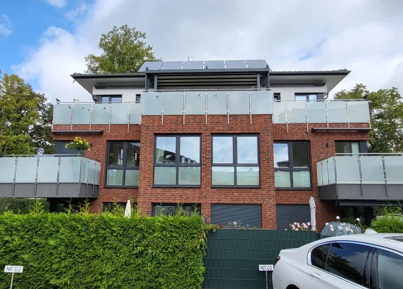 Mehrfamilienhaus mit Klinkerfassade und Balkon mit Edelstahlgeländer