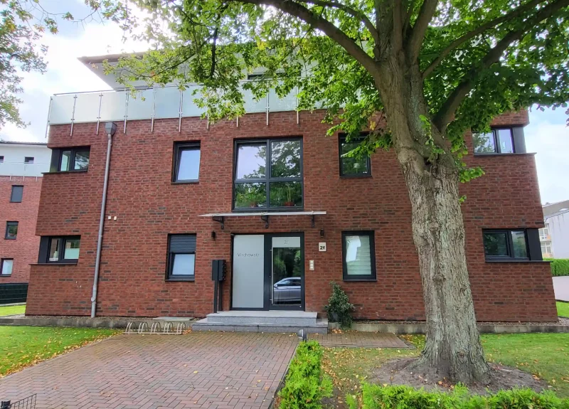 Mehrfamilienhaus mit Klinkerfassade und Balkon mit Edelstahlgeländer