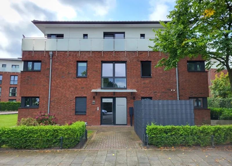 Mehrfamilienhaus mit Klinkerfassade und Balkon mit Edelstahlgeländer