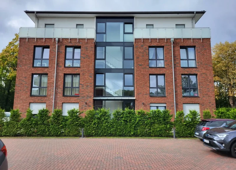 Mehrfamilienhaus mit Klinkerfassade und Balkon mit Edelstahlgeländer