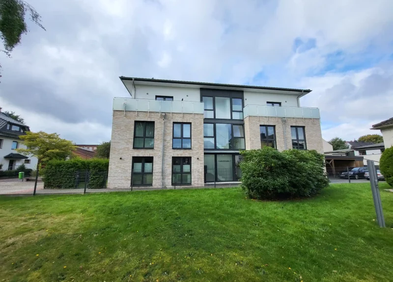 Mehrfamilienhaus mit Klinkerfassade und Balkon mit Edelstahlgeländer