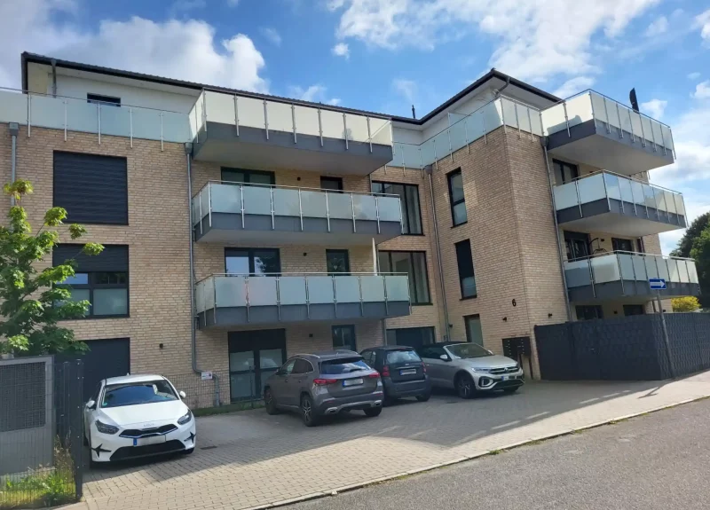 Mehrfamilienhaus mit einer Klinker-Verblendung und Balkonen mit Edelstahlgeländern