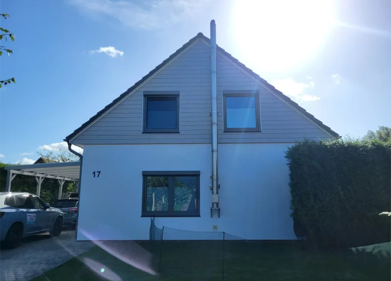 Einfamilienhaus mit einer glatten Fassade und einer Holzoptik im OG