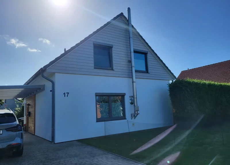 Einfamilienhaus mit einer glatten Fassade und einer Holzoptik im OG