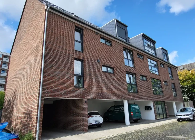 Mehrfamilienhaus mit einer Klinker-Verblendung und Garagen
