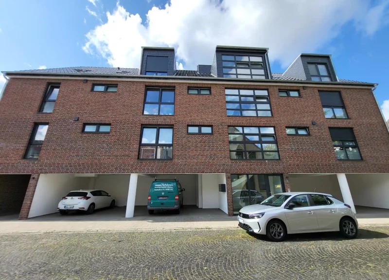 Mehrfamilienhaus mit einer Klinker-Verblendung und Garagen